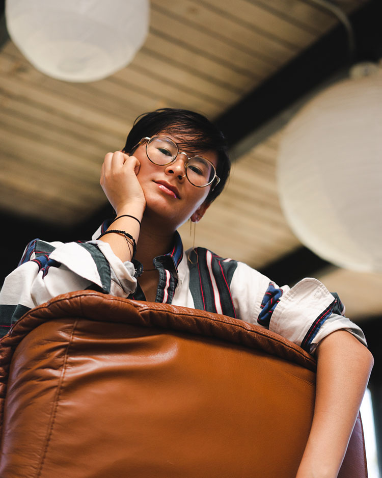 Person looking over recliner back into camera.