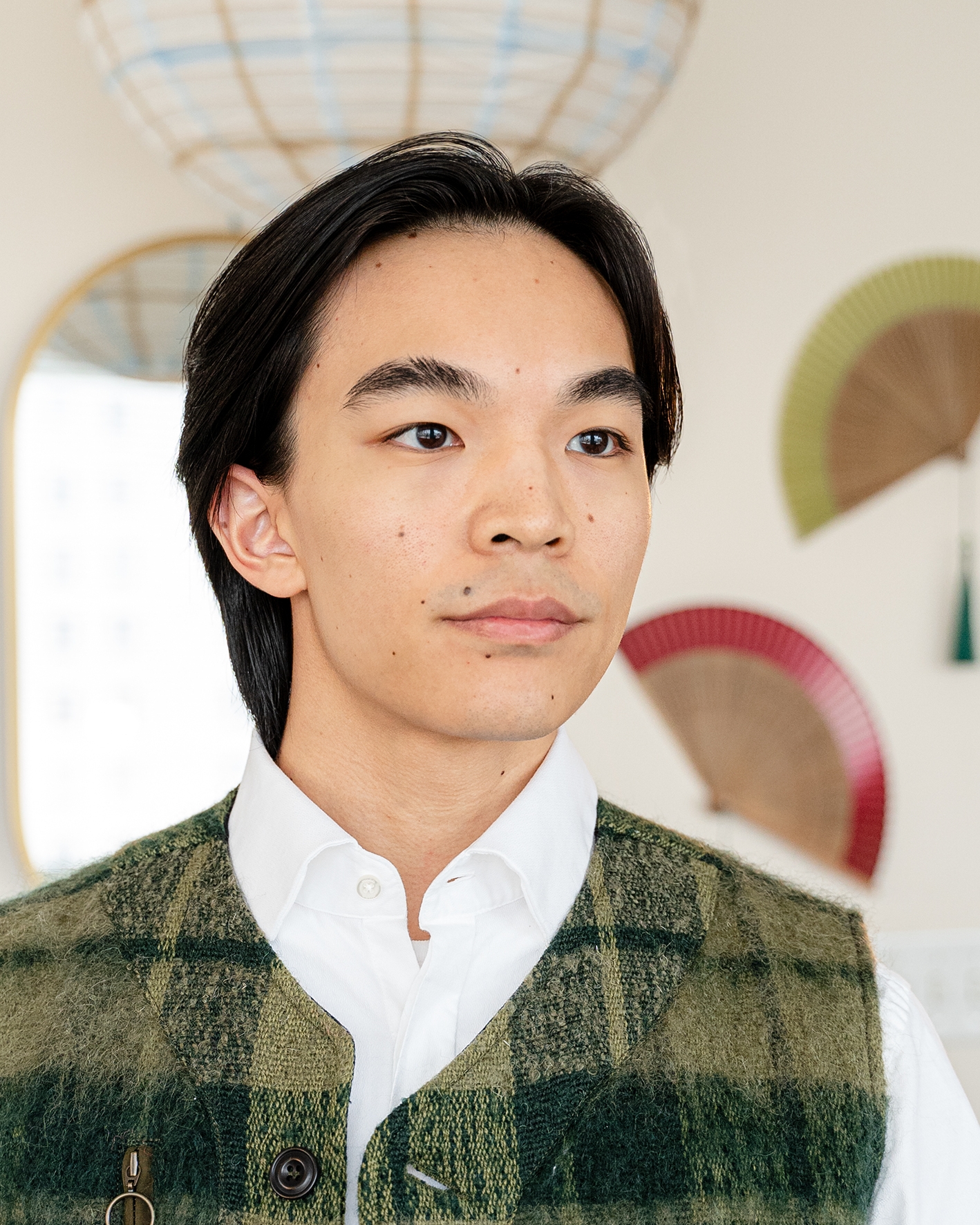 Portrait of Barrett in a white collared shirt and green vest.